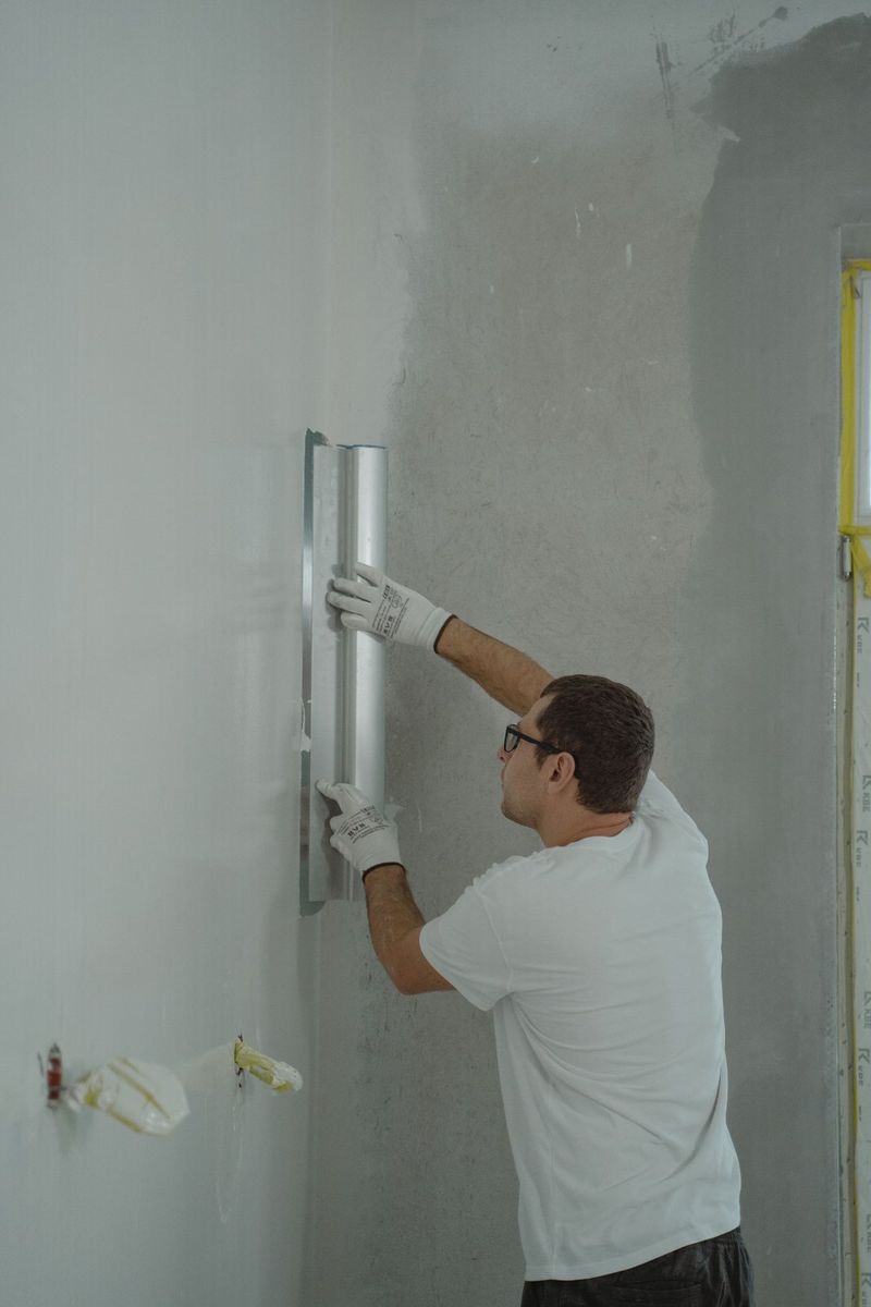 Worker finishing new drywall with a trowel