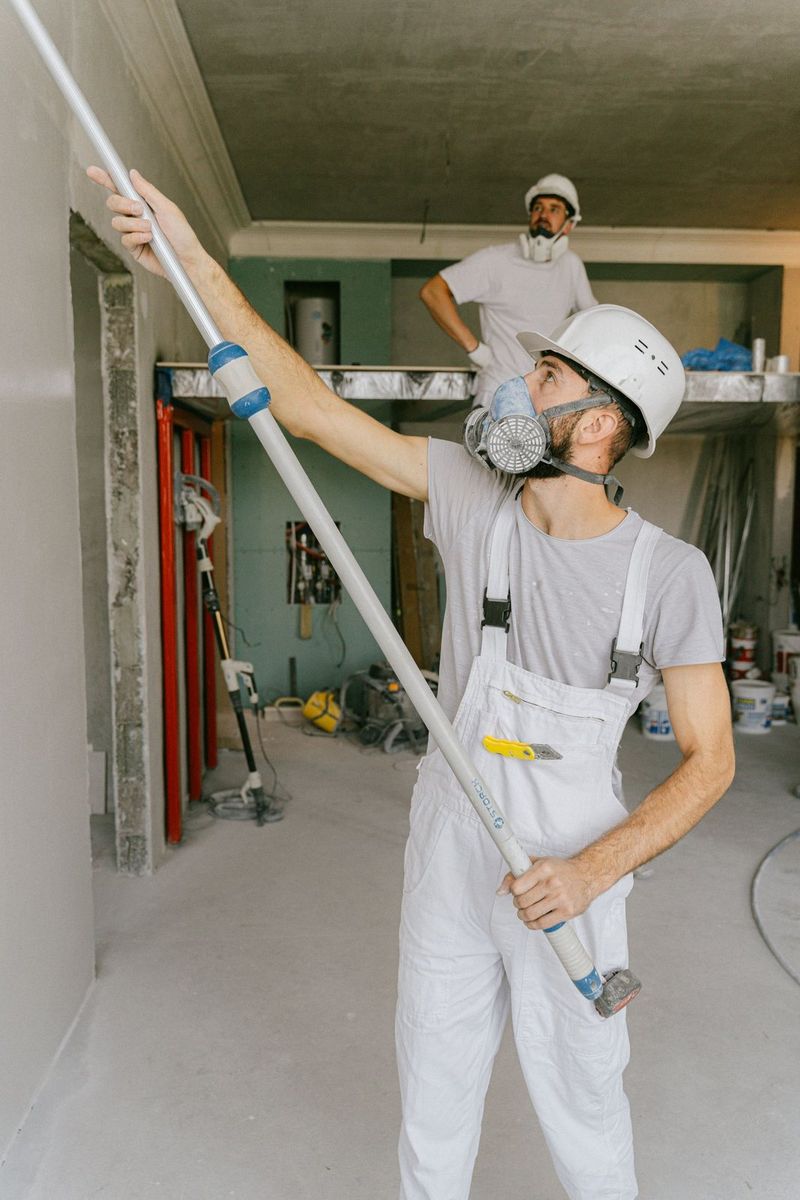 Technician in a respirator inspecting a ceiling